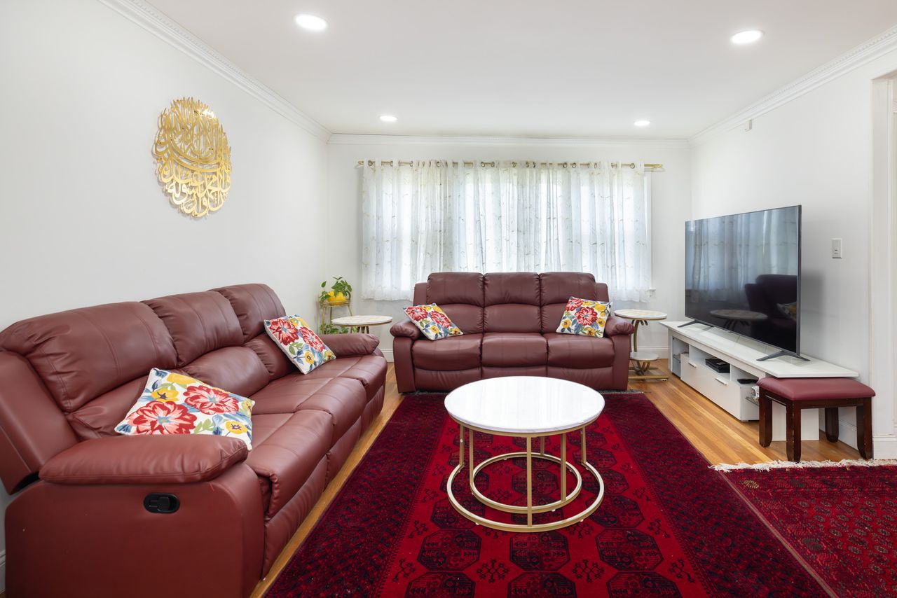 Living room with leather sofas and a red rug