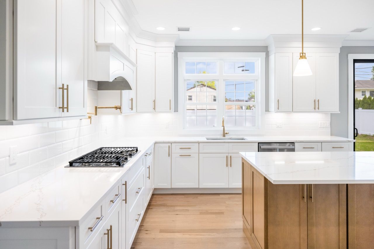 White kitchen with a wood island and gold pendant lights