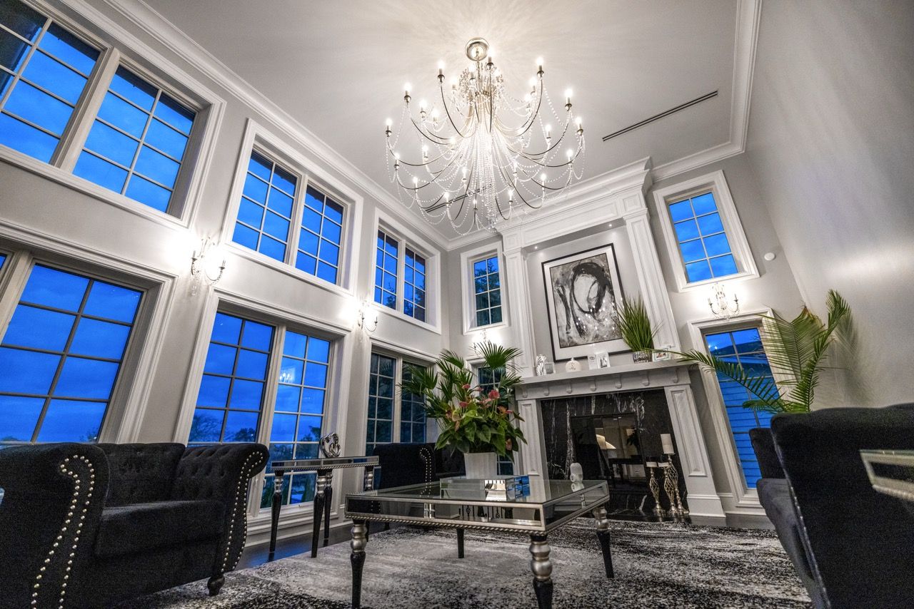 Double-height living room with a crystal chandelier