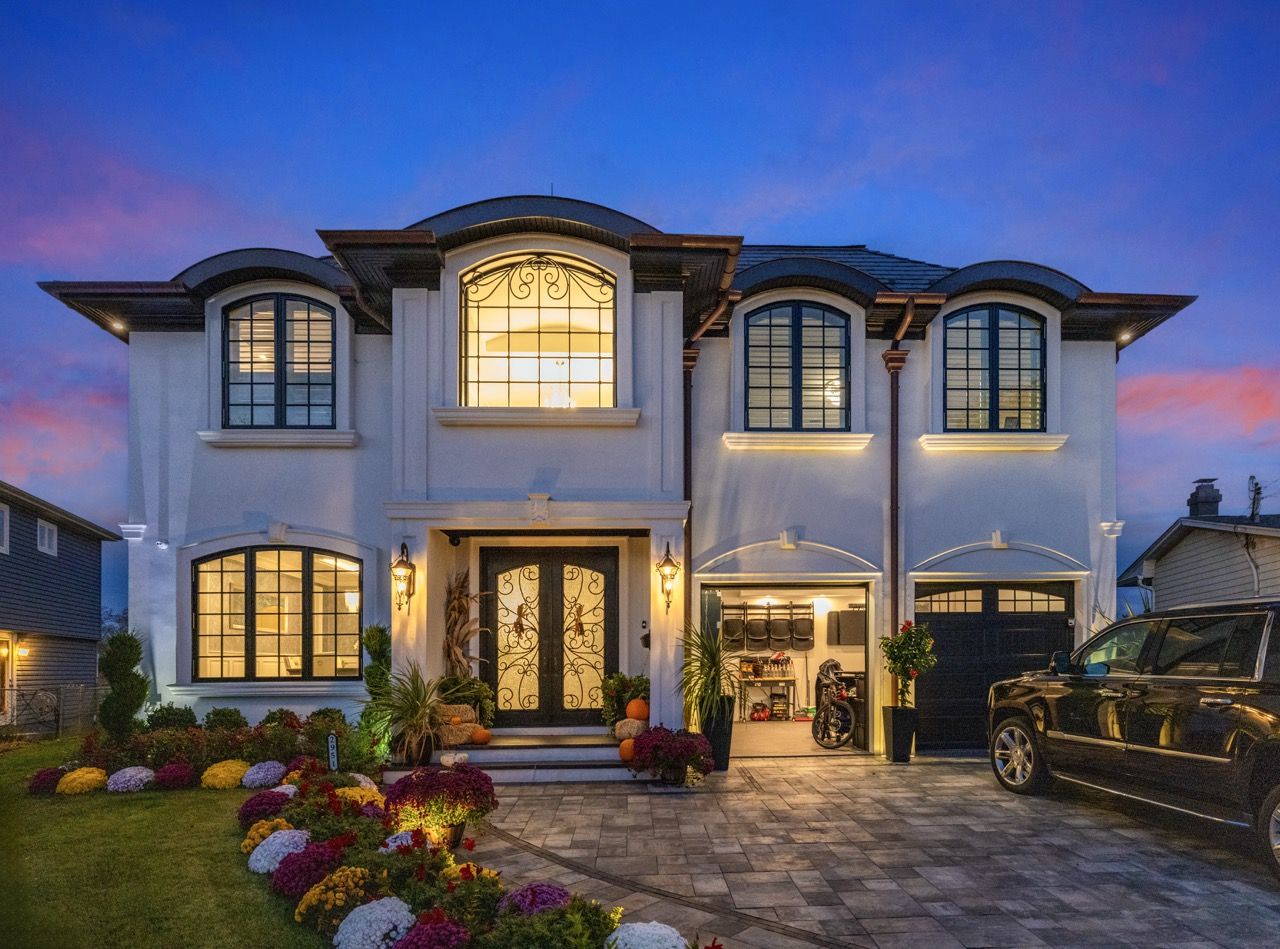 Two-story home at twilight with every light on