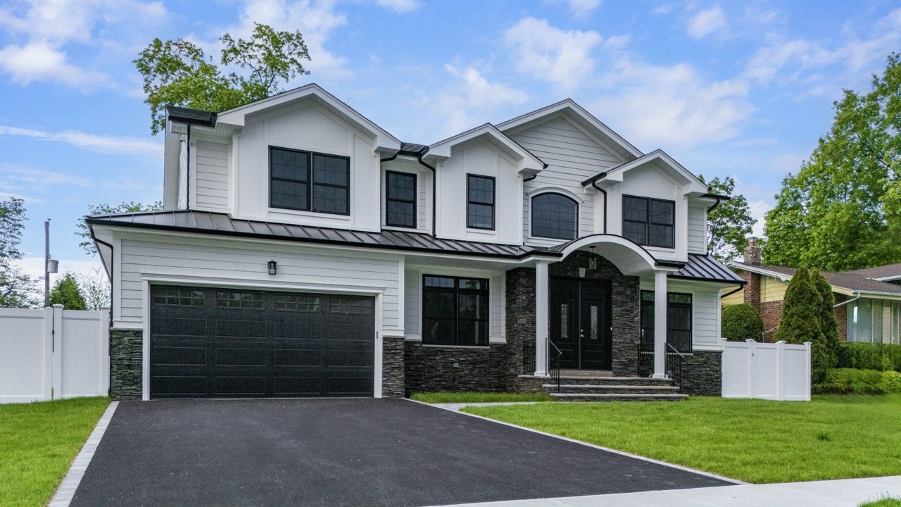 Front of a new white home with a black two-car garage