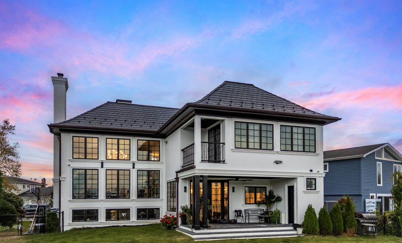 Rear of a home at twilight with lit windows