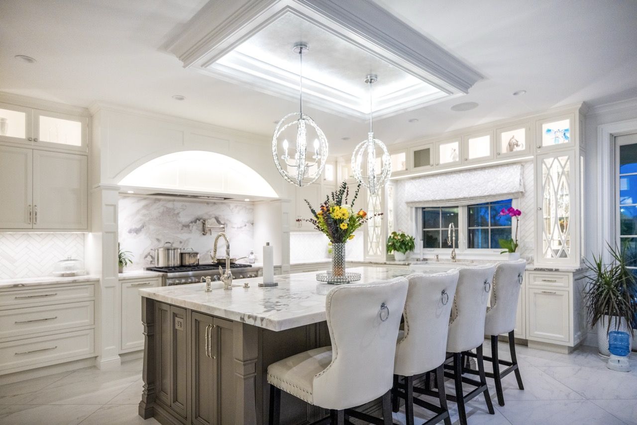 White kitchen with a large island and globe pendant lights